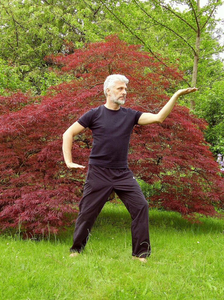 Man op een grasveld die Qigong beoefend.