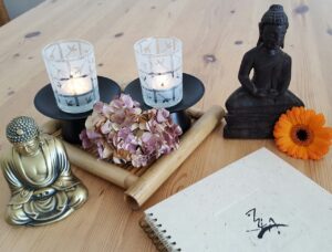 beelden, kaarsen op een houten tafel. Boek met chinese tekens over qigong