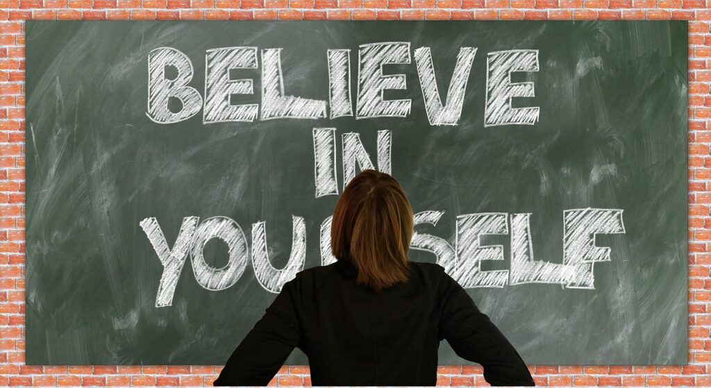 Versterk je zelfvertrouwen. Geloog in je zelf in het engles op een schoolbord geschreven.