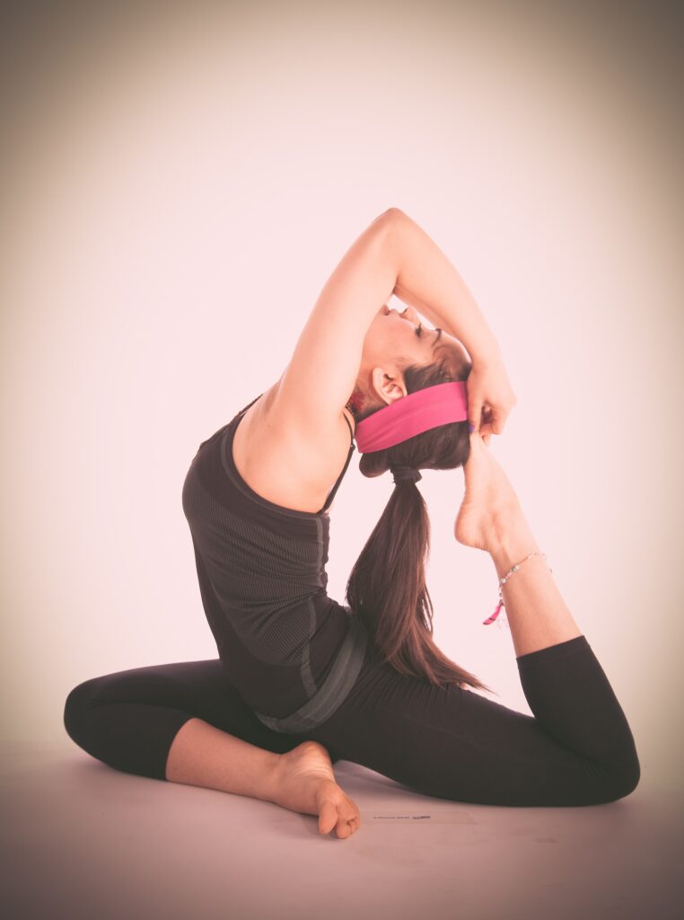 Vrouw doet yoga pose met een voet in haar nek